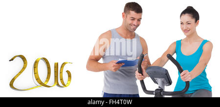 Composite image of trainer with client on exercise bike Stock Photo