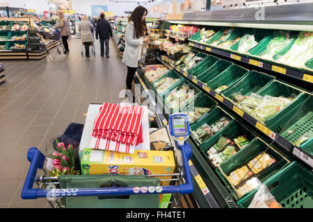A full shopping trolley in the fruit and vegetables aisle, Tesco supermarket Suffolk UK Stock Photo
