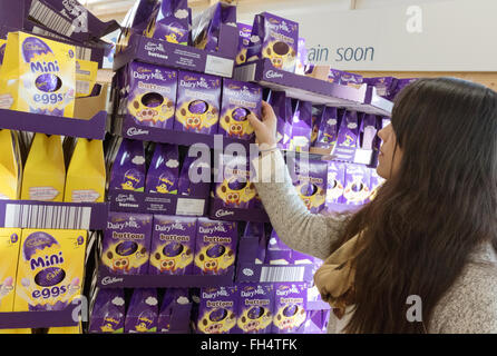 A woman buying easter eggs in a Tesco supermarket store, Suffolk UK Stock Photo