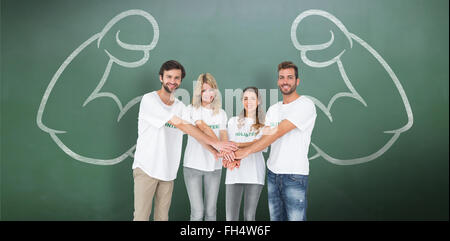 Composite image of group portrait of happy volunteers with hands together Stock Photo