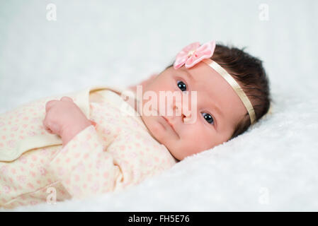 Cute newborn baby girl with pink bow Stock Photo