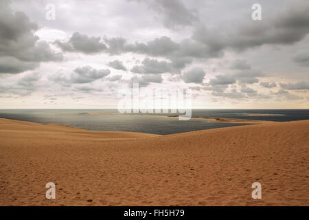 Dune of Pilat, view over the ocean and cloudy sky. Dune du Pilat, the tallest sand dune in Europe, located in the Arcachon Bay a Stock Photo