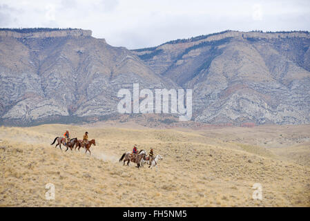 Cowboys and Cowgirls riding horse in wilderness, Rocky Mountains, Wyoming, USA Stock Photo
