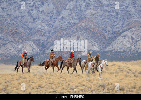 Cowboys and Cowgirls riding horses in wilderness, Rocky Mountains, Wyoming, USA Stock Photo
