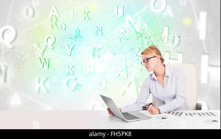Business woman at desk with green word cloud Stock Photo