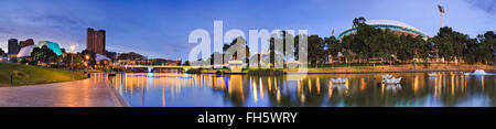 panorama of Adelaide city centre over Torrens river at sunrise. From CBD high-rises to oval in public park with blurred water Stock Photo