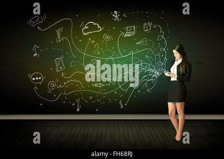 Businesswoman sitting in chair holding tablet with media icons Stock Photo