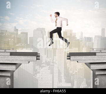 Energetic business man jumping over a bridge with gap Stock Photo