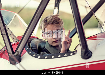 Germany, Dierdorf, Boy sitting in biplane Stock Photo