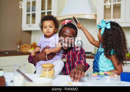 Cute girl brushing her father hair Stock Photo