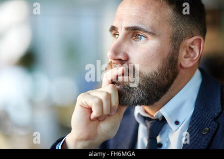 Pensive man touching his chin Stock Photo