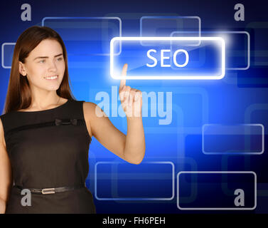 Woman presses forefinger button with an inscription SEO Stock Photo