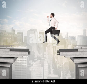 Energetic business man jumping over a bridge with gap Stock Photo