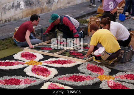 People create elaborate images from vividly coloured flower petals and grass seeds during the Corpus Christi Alfombra or Flower Carpet event in the town of La Orotava in the northern part of Tenerife island in Canary Islands, Spain on 11 June 2015. The Corpus Christi flower carpets in La Orotava is an annual tradition in which the streets are decorated with carpets made from flower petals and other plant parts with pictures depicting various religious scenes. Stock Photo