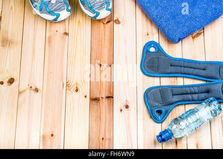 Fitness Equipment. Sport Shoes, Tower, Wrist Weights And Bottle Of Water On Boards. Sport Fitness Background Stock Photo