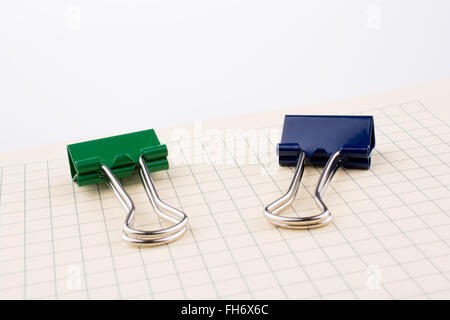 Colored paper clip on a checked notebook  page Stock Photo