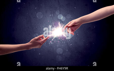 Hands reaching to light a spark Stock Photo