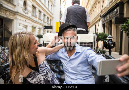 Austria, Vienna, couple having fun on sightseeing tour in a fiaker Stock Photo