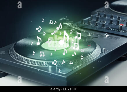 Turntable playing music with audio notes glowing Stock Photo