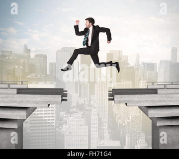 Energetic business man jumping over a bridge with gap Stock Photo