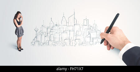 Businesswoman looking at hand drawn city on wall Stock Photo
