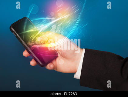 Hand holding smart phone with abstract glowing lines Stock Photo