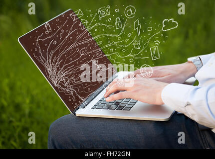 Man pressing notebook laptop computer with doodle icon cloud symbols Stock Photo