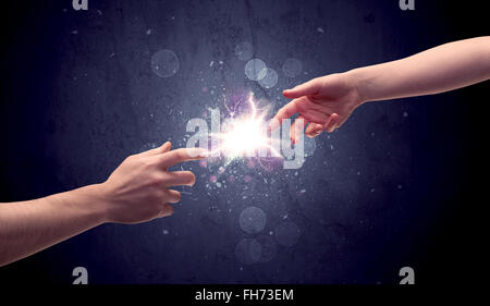 Hands reaching to light a spark Stock Photo