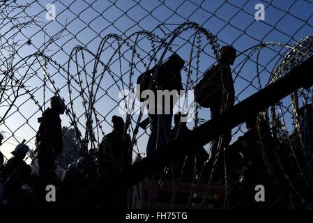 Skopje. 24th Feb, 2016. Afghan migrants protest and stand behind the wire fencing at the closed Greek-Macedonian border, near the Macedonian city of Gevgelija on Feb. 23, 2016. Macedonia has confirmed that it only allowed Syrian and Iraqi refugees through, matching a decision by its northern neighbor, Serbia. Around 5,000 migrants were waiting at the border wishing to continue their journey across Macedonia, Serbia, Croatia, Slovenia and then Austria, with Germany the final goal for most. © Xinhua/Alamy Live News Stock Photo