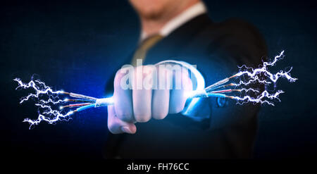 Business person holding electrical powered wires Stock Photo