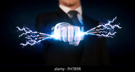 Business person holding electrical powered wires Stock Photo