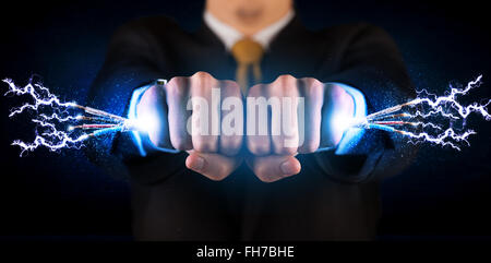 Business person holding electrical powered wires Stock Photo