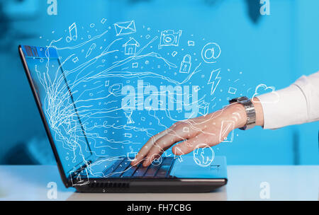 Man pressing notebook laptop computer with doodle icon cloud symbols Stock Photo