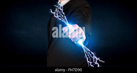 Business person holding electrical powered wires Stock Photo