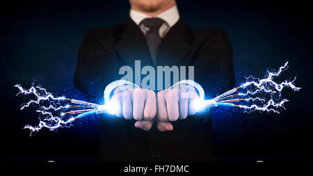 Business person holding electrical powered wires Stock Photo