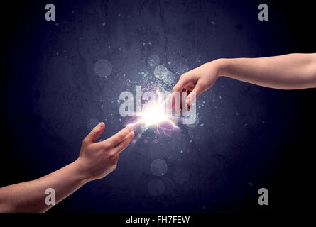 Hands reaching to light a spark Stock Photo