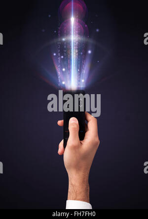 Hand with remote control and shining numbers Stock Photo