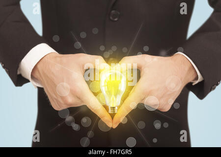 Hands creating a form with light bulb Stock Photo