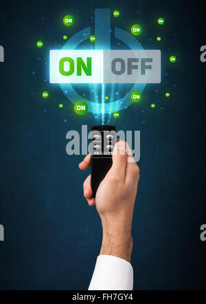 Hand with remote control and on-off signals Stock Photo