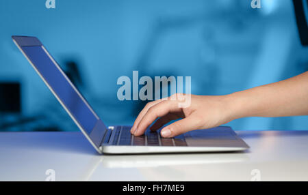 Businessman pressing modern laptop computer on colorful background Stock Photo