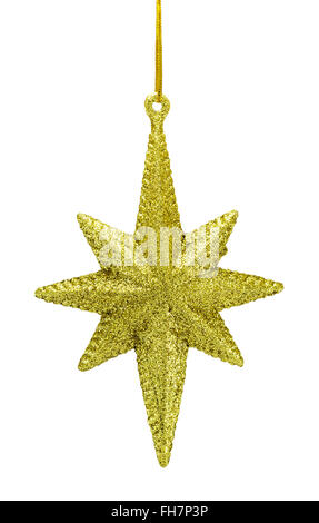 Gold glitter star ornament hanging from a Christmas tree against a ...
