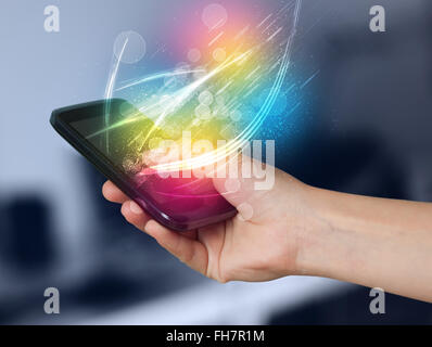 Hand holding smart phone with abstract glowing lines Stock Photo