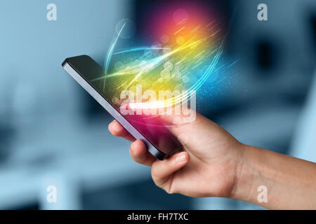 Hand holding smart phone with abstract glowing lines Stock Photo