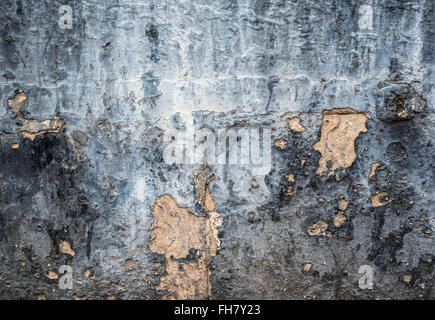 Dry, flaking plaster and paint on a wall background. Stock Photo