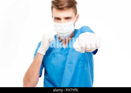 Male doctor hitting at camera isolated on a white background Stock Photo