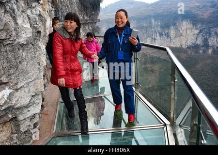 Tongren, China's Guizhou Province. 24th Feb, 2016. Tourists walk on a glass skywalk in the National Mine Park of Tongren City, southwest China's Guizhou Province, Feb. 24, 2016. The 1,005-meter-long and 1.6-meter wide glass skywalk, with more than 100 meters above the valley bottom, has passed a safety test and will be opened to the public in May. Credit:  Liu Xu/Xinhua/Alamy Live News Stock Photo