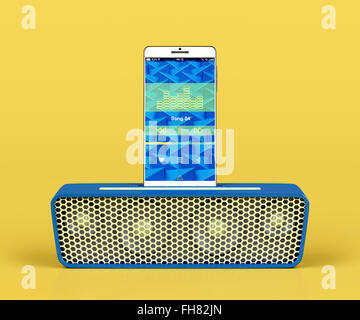 Front view of docking station speaker and smartphone on yellow background Stock Photo