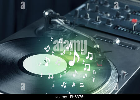 Turntable playing music with audio notes glowing Stock Photo