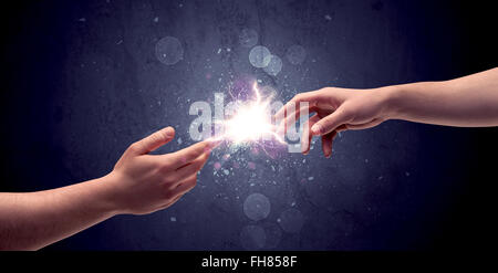 Hands reaching to light a spark Stock Photo