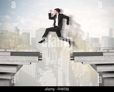 Energetic business man jumping over a bridge with gap Stock Photo